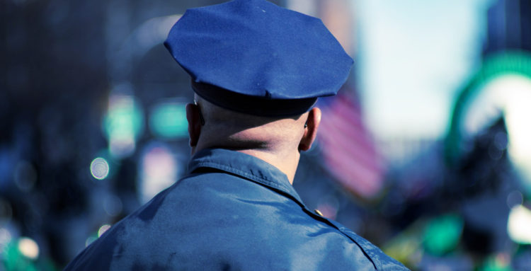 the back of a police officers head while he wears his cop cap